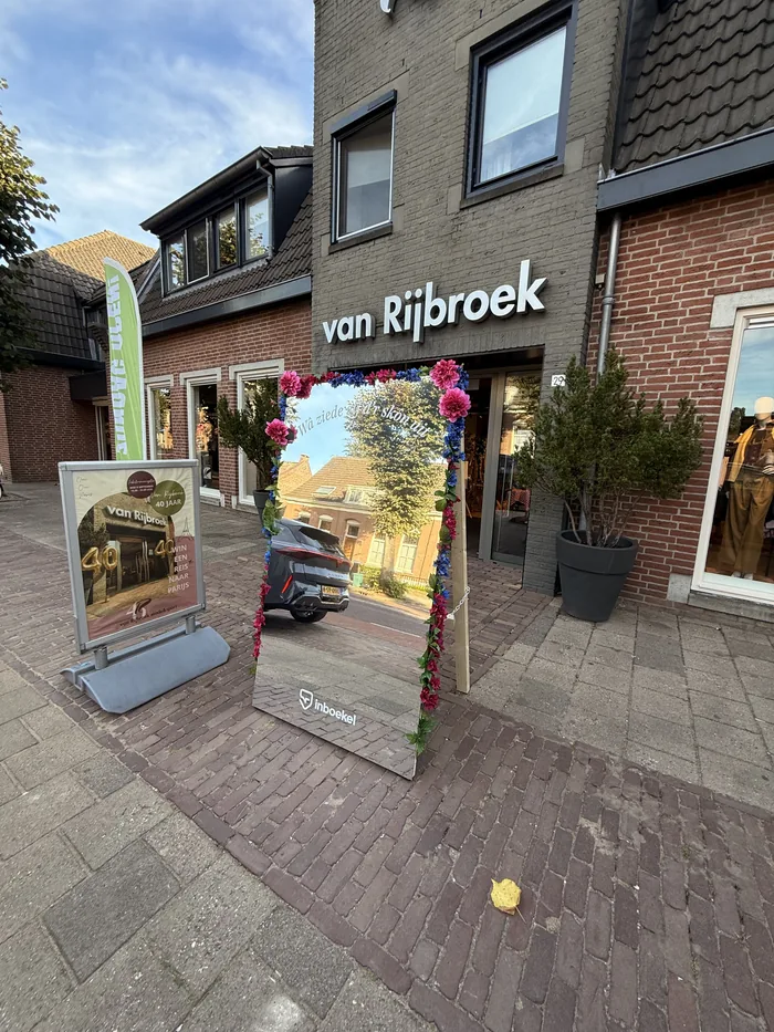 Feestspiegel met bloemen voor de deur bij Van Rijbroek